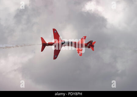 Deux British Aerospace Hawk à réaction militaire de la Royal Air Force des flèches rouges Aerobatic Display Team effectuer un tête à tête de traverser à RIAT Banque D'Images