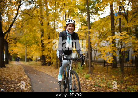 La photo d'une femme en vélo le long du chemin de casque Banque D'Images