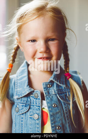 Closeup portrait of cute adorable blonde Woman smiling girl à huis clos. La fille aux cheveux de lumière avec tresses, portant des pays Banque D'Images