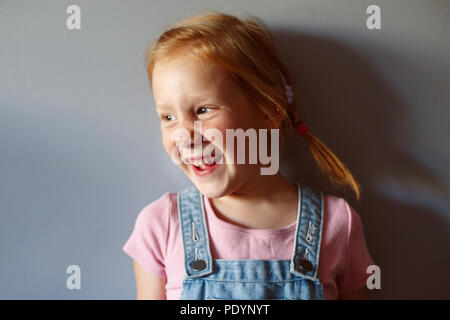 Closeup portrait of cute adorable preschool girl laughing Caucasian rousse. Sourire de l'enfant s'amuser faire des grimaces. Tonique avec des filtres. Banque D'Images