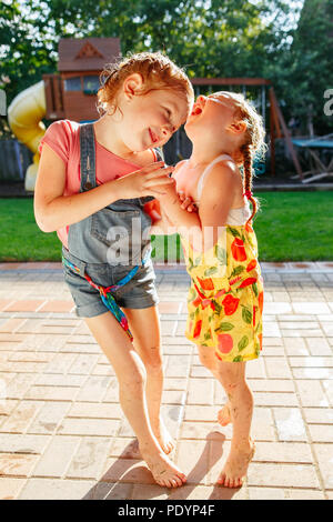 Portrait de deux petites filles, sœurs s'amusant sur l'arrière-cour d'accueil. Des visages amis filles stupides. Famille moment de vie bien positionné en couverture siblings playing Banque D'Images