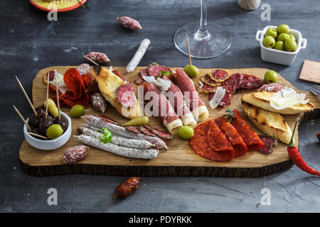 Des tapas espagnoles. concept : tranches de jamon variété, du chorizo, du salami, des bols d'olives, de poivrons. Copyspace. Banque D'Images