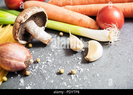 Cuisine des ingrédients comme l'oignon, l'ail, champignons, carottes ou d'épices sur ardoise Banque D'Images