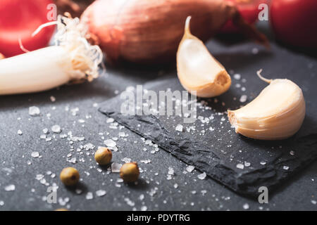 Cuisine des ingrédients comme l'ail, l'oignon ou d'épices sur ardoise Banque D'Images