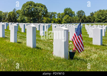 Le drapeau national des États-Unis avec des pierres tombales blanches dans l'arrière-plan au Camp Butler National Cemetery Banque D'Images