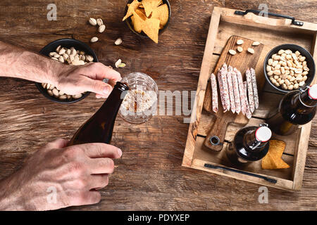 Man pouring beer dans du verre de la bouteille Banque D'Images