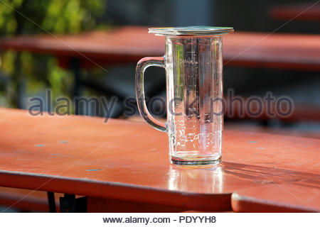 Une paire de dessous de bière un verre de bière vide couvercle par temps chaud sur une soirée allemande Banque D'Images