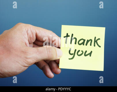 C'est main tenant memo stick avec signe merci. Banque D'Images