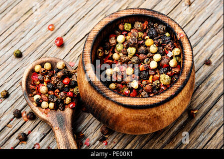 Assortiment de grains de poivre dans la boîte sur un fond de bois Banque D'Images