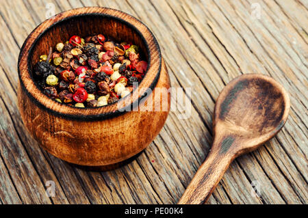 Assortiment de grains de poivre dans la boîte sur un fond de bois Banque D'Images