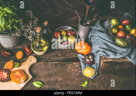 Table de cuisine rustique en bois sombre avec des tomates de la ferme, les ingrédients et outils de cuisine. Arrière-plan de l'alimentation, style de vie encore, vu de dessus. Plac Banque D'Images