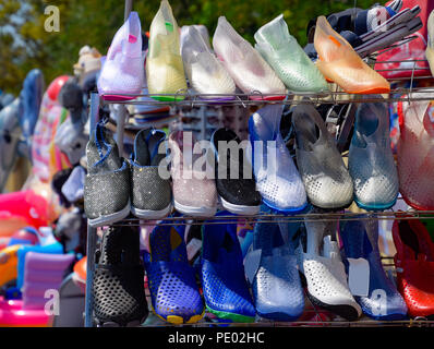 Sandales en caoutchouc et silicone et sneakers sur le plateau de chaussures sur le marché. Banque D'Images