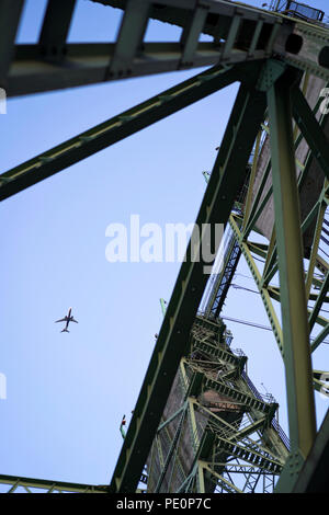 Un avion dans le ciel vole au-dessus de Colombie-Britannique Interstate bridge de levage avec des tours avec des contrepoids en béton pour augmenter la partie du pont de levage Banque D'Images