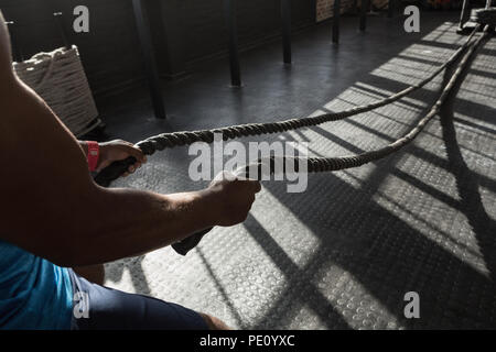 Man faisant corde crossfit formation dans le studio de remise en forme Banque D'Images