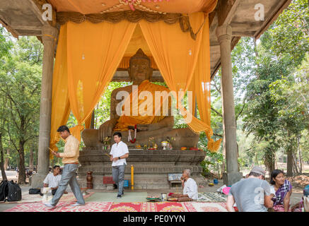 Les fidèles priant devant une grande statue de Bouddha assis jambes croisées, Wat Preah Ngok (ou Preah Ngoc), Angkor, Krong Siem Reap, Cambodge Banque D'Images