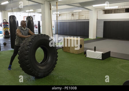 Hauts homme pneu crossfit flip dans le studio de remise en forme Banque D'Images