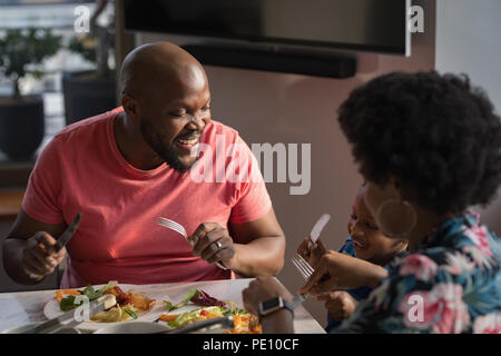 Famille de prendre le petit déjeuner sur une table à manger Banque D'Images