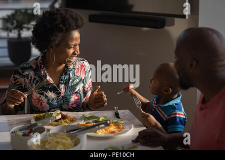 Famille de prendre le petit déjeuner sur une table à manger Banque D'Images