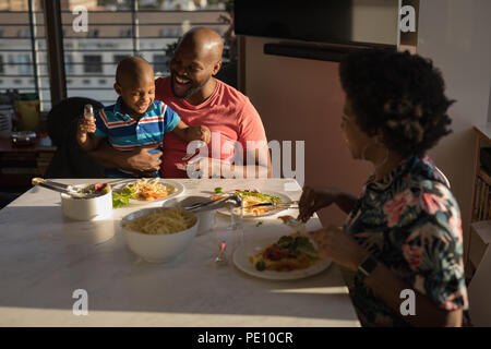 Famille de prendre le petit déjeuner sur une table à manger Banque D'Images