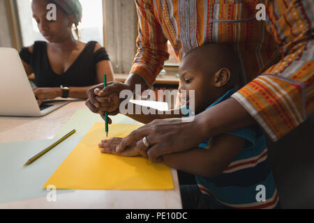 Père d'aider son fils à faire un croquis Banque D'Images