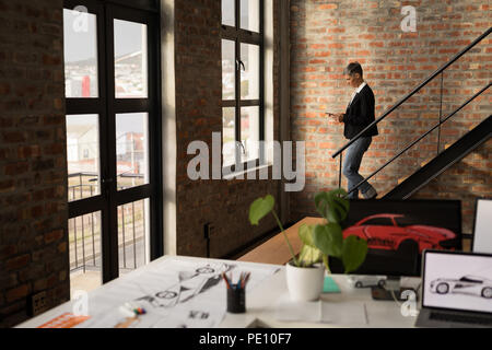 Businesswoman using mobile phone en marchant en bas Banque D'Images