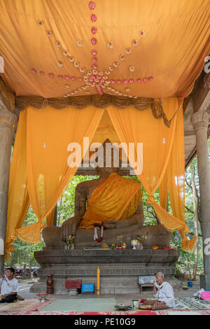 Les fidèles priant devant une grande statue de Bouddha assis jambes croisées, Wat Preah Ngok (ou Preah Ngoc), Angkor, Krong Siem Reap, Cambodge Banque D'Images