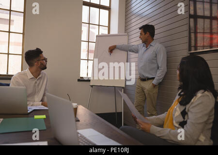 Businessman donnant une présentation sur tableau blanc tableau dans la salle de conférence Banque D'Images