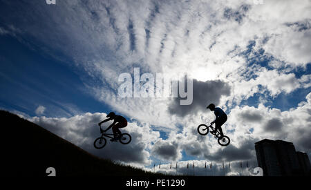 Les cavaliers sont silhouetté contre le ciel au cours de la 1/8 de finale hommes pendant dix jours des Championnats d'Europe 2018 à la Glasgow Centre BMX Piste. Banque D'Images
