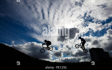 Les cavaliers sont silhouetté contre le ciel au cours de la 1/8 de finale hommes pendant dix jours des Championnats d'Europe 2018 à la Glasgow Centre BMX Piste. Banque D'Images