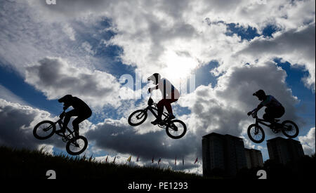 Les cavaliers sont silhouetté contre le ciel au cours de la 1/8 de finale hommes pendant dix jours des Championnats d'Europe 2018 à la Glasgow Centre BMX Piste. Banque D'Images