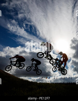 Les cavaliers sont silhouetté contre le ciel au cours de la 1/8 de finale hommes pendant dix jours des Championnats d'Europe 2018 à la Glasgow Centre BMX Piste. Banque D'Images