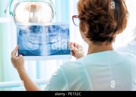 Un dentiste examine orthopantomogram dans ses mains Banque D'Images