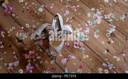 Paire de dames chaussures de mariage sur le plancher couvert de confettis Banque D'Images