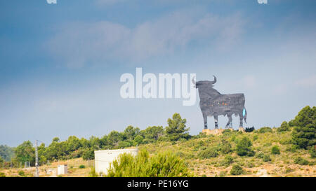 Toro Osborne, symbole de l'Espagne, silhouette de taureau noir sur la colline avec green bush à l'avant-plan. Banque D'Images