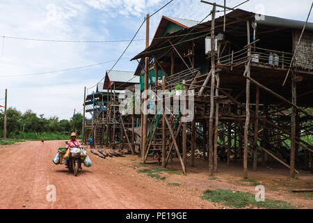 Une femme sur une moto chargé jusqu'à Kampong Phluk, l'un des "villages flottants du Cambodge' de Tonle Sap, au cours de la saison sèche. Banque D'Images
