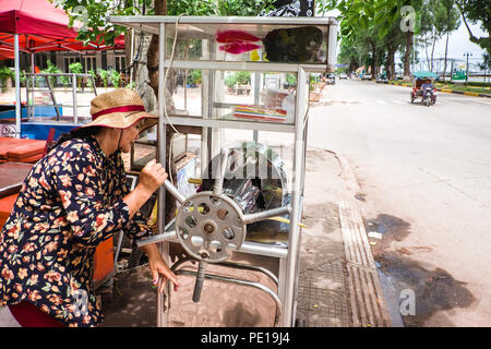 Une femme vendeur de rue, la vente de jus de palme à Kampot, Cambodge Banque D'Images