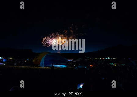 Feux d'artifice après la nuit brillent à l'événement de montgolfière Bristol International Balloon Fiesta. Ballons dégonflés. Nuit. Sombre Banque D'Images