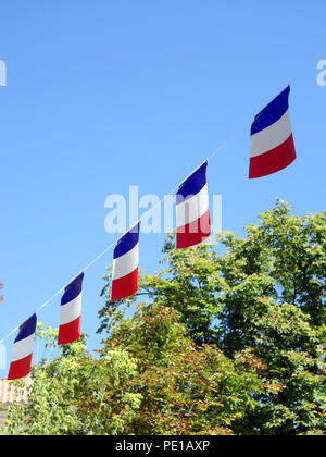 Chaîne française dans les rangées des bannières drapeau flottant dans un ciel bleu d'été à Cessenon-sur-Orb, France Banque D'Images