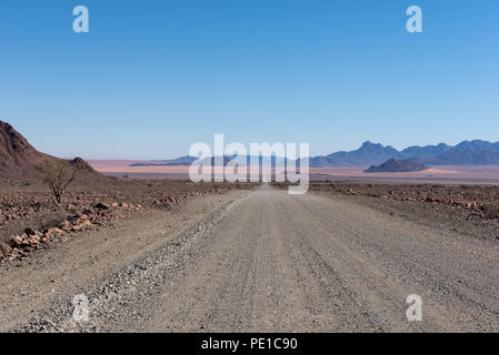 Vide tout droit de gravier dans le lointain avec de belles montagnes en arrière-plan Banque D'Images