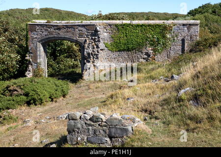 Un vieux mur de l'entrée en pierre isolée de ce qui était autrefois un grand château en haut d'une colline, près de la côte dans une belle région. Banque D'Images