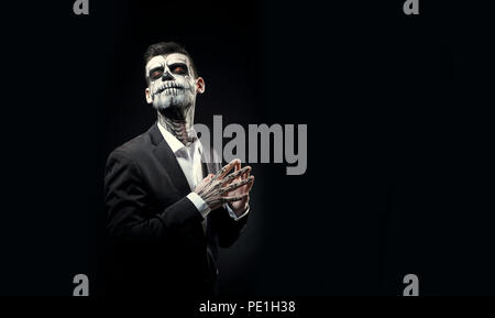 Portrait d'un homme avec un miroir sur le crâne Halloween black background Banque D'Images