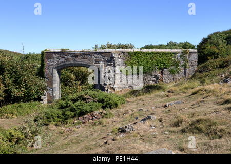 Un vieux mur de l'entrée en pierre isolée de ce qui était autrefois un grand château en haut d'une colline, près de la côte dans une belle région. Banque D'Images