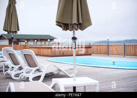 Country club loisirs loisirs piscine détente maison en bois les arbres forestiers transat parasol. Paysage naturel magnifique Banque D'Images