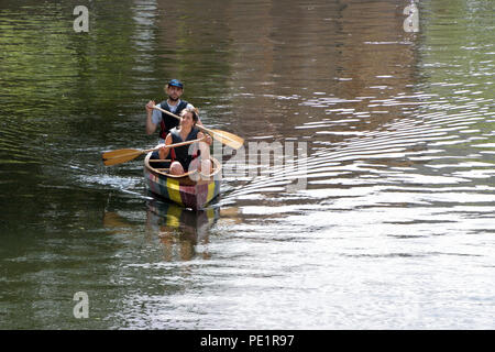 Jeune couple une pagaie canoë canadien le long de la rivière Wensum par Norwich, Norfolk, près de pont de l'af. Banque D'Images