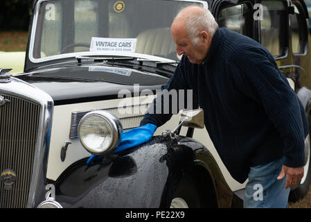 Nettoyage et polissage de la voiture d'époque de l'exposant lors du salon annuel de la société agricole d'Ellingham et Ringwood, dans la campagne ouest du Hampshire, Angleterre, Royaume-Uni, 11th août 2018. Banque D'Images