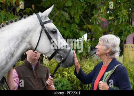 Ellingham, Ringwood, New Forest, Hampshire, Angleterre, Royaume-Uni, 11th août 2018. Une femme âgée aux cheveux gris vient face à face avec un cheval blanc au salon annuel de la Société agricole d'Ellingham et Ringwood dans la campagne ouest du comté. Banque D'Images