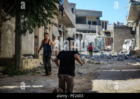 Idlib, en Syrie. 10 août, 2018. Un enfant est considéré dans les bâtiments détruits.9 militants anti Gouvernement sont morts et plus de 45 blessés à la suite d'un intense bombardement de la ville de Khan Shikhon par le régime syrien, l'aviation et de l'hélicoptère. Credit : Anas Aldyab SOPA/Images/ZUMA/Alamy Fil Live News Banque D'Images