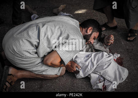 Idlib, en Syrie. 10 août, 2018. (NOTE de l'ÉDITEUR : IMAGE REPRÉSENTE LA MORT).Un homme vu le deuil à côté d'un corps mort.9 militants anti Gouvernement sont morts et plus de 45 blessés à la suite d'un intense bombardement de la ville de Khan Shikhon par le régime syrien, l'aviation et de l'hélicoptère. Credit : Anas Aldyab SOPA/Images/ZUMA/Alamy Fil Live News Banque D'Images