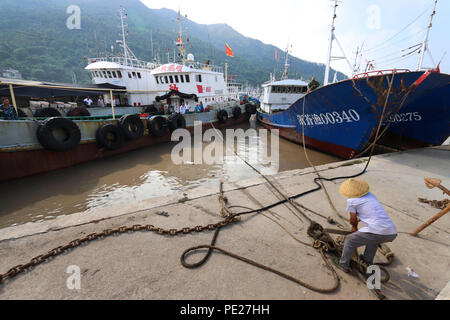 Zhejiang, Chine. 12 août 2018. (180812) -- WENZHOU, le 12 août 2018 (Xinhua) -- Un pêcheur anchors son bateau dans un refuge à l'abri de Yagi typhoon dans un port dans la ville de Cangnan de Wenzhou, province de Zhejiang, Chine orientale, le 12 août 2018. L'observatoire national de dimanche a publié une alerte bleue pour Yagi typhon qui a renforcé l'avance de ses côtes de la région côtière de l'Est. Source : Xinhua/Alamy Live News Banque D'Images