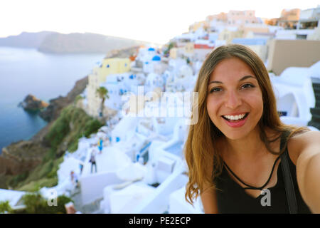 Self Portrait of smiling girl dans le village d''Oia, Santorin. Happy cute girl taking photo selfies touristiques pendant les vacances d'été en Europe célèbre desti Banque D'Images